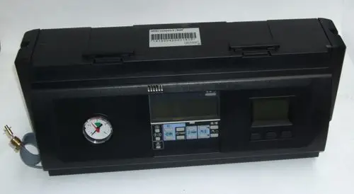 Schwarze Steuereinheit von Daikin mit analogen und digitalen Anzeigen, Druckmesser und Bedientasten auf der Vorderseite. Ein Anschluss mit Schlauch ist seitlich sichtbar.